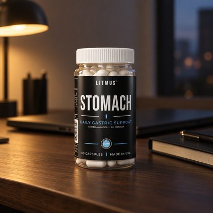 STOMACH jar on a wooden desk in the evening, with a laptop, a desk lamp and a notebook behind it.
